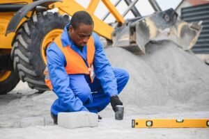 Construction worker installing concrete pavers with precision at a residential job site in North Royalton OH.