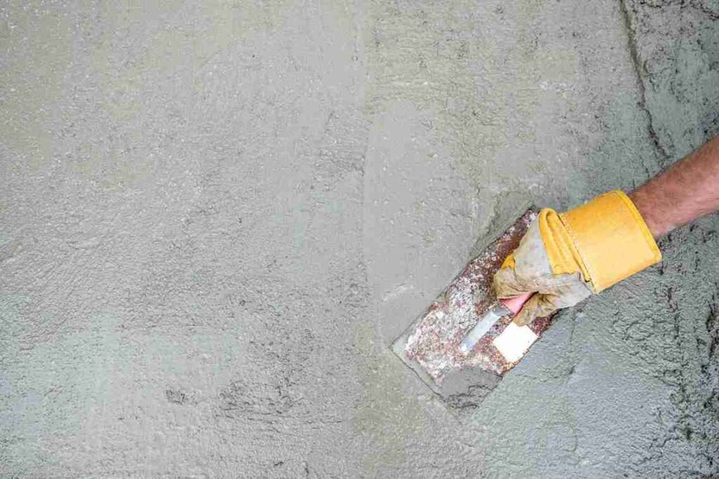 Worker repairing and resurfacing an old concrete surface to restore strength in North Royalton OH.